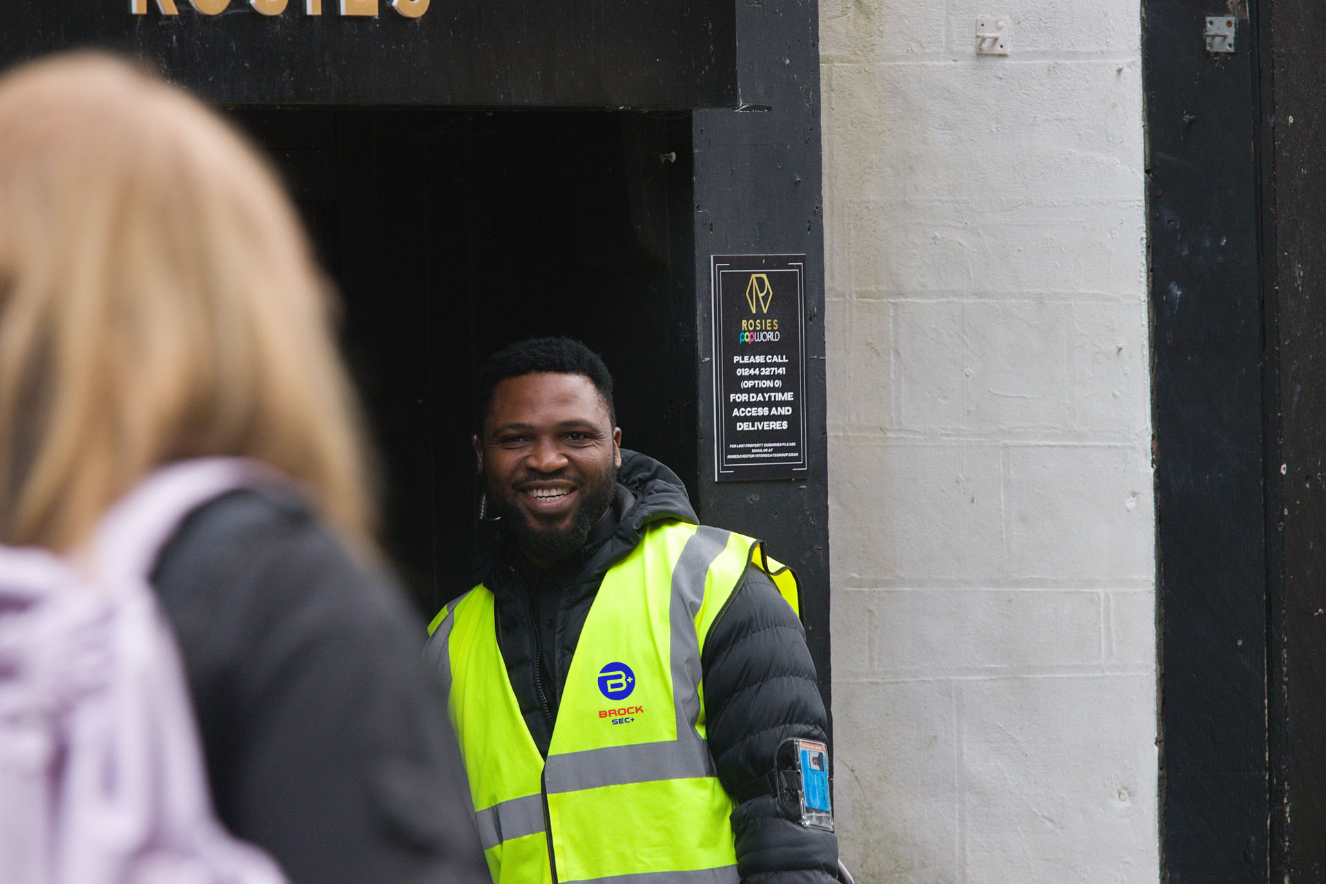 A,Nightclub,Security,Guard,Smiling,Outside,An,Entrance,To,A